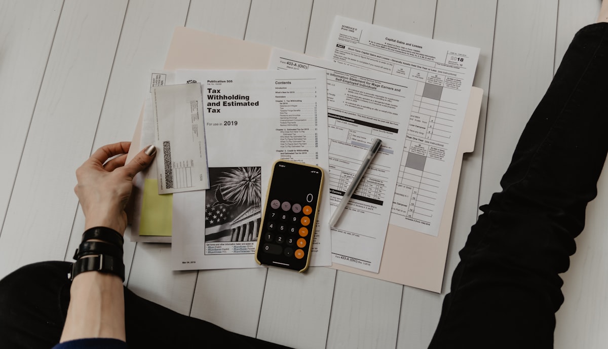 Calculator, tax documents and financial records on a desk representing Making Tax Digital compliance